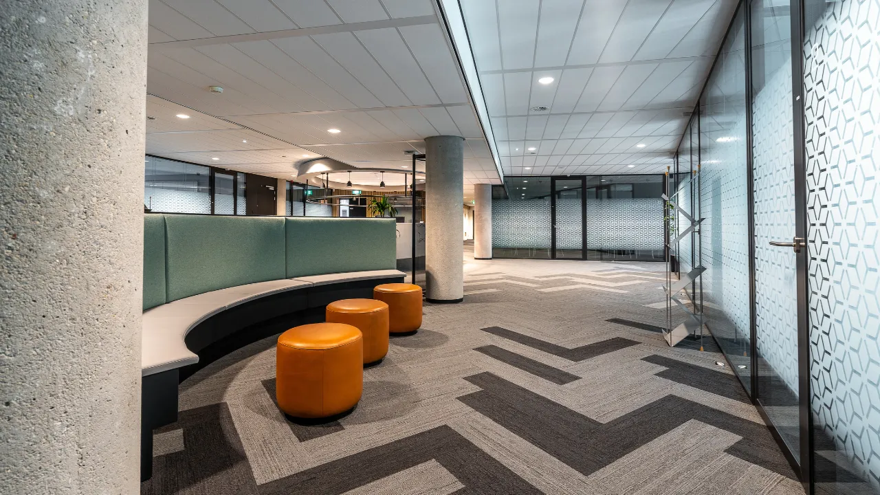 Ambiente comercial com forro modular e iluminação embutida, demonstrando soluções de forro para espaços comerciais contemporâneos.
